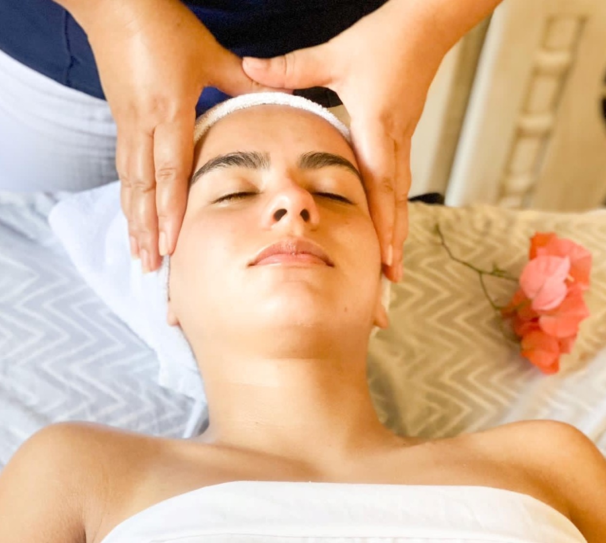 A woman getting her face washed with a towel.